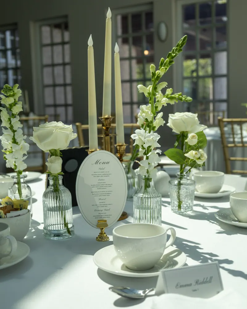 Wedding reception table setting with candles, florals, and a menu card at Assiniboine Park